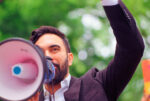 Zohran Mamdani speaking into a bullhorn at Fort Greene Park in Brooklyn on 5/24/2025