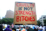 Sign at the Newark No Kings rally written in red and black on cardboard that reads "CRUELTY IS NOT STRENGTH BITCHES."