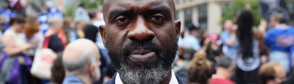 Michael Blake at NYC rally, protestors behind him.