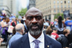 Michael Blake at NYC rally, protestors behind him.