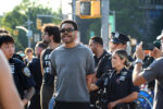 Eon Huntley, arrested at the Families Stand With Gaza rally, continues chanting as cops lead him towards the camera. His hands are tied behind his back.