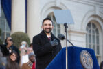 Mamdani smiles, hand to his heart, as he stands at the podium during his inauguration.